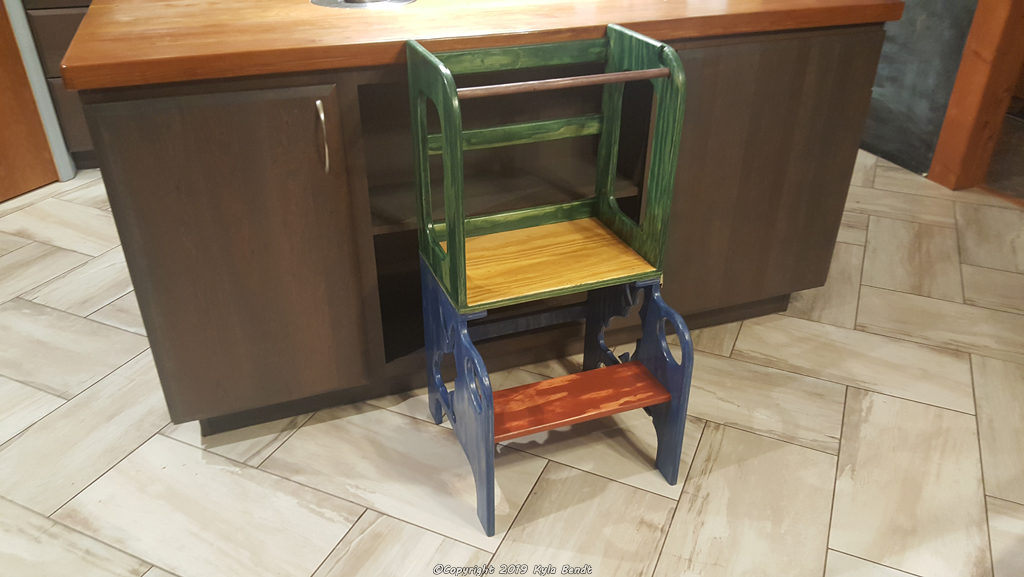 A colorful kid's step stool with bunny cutouts and a safety bar.