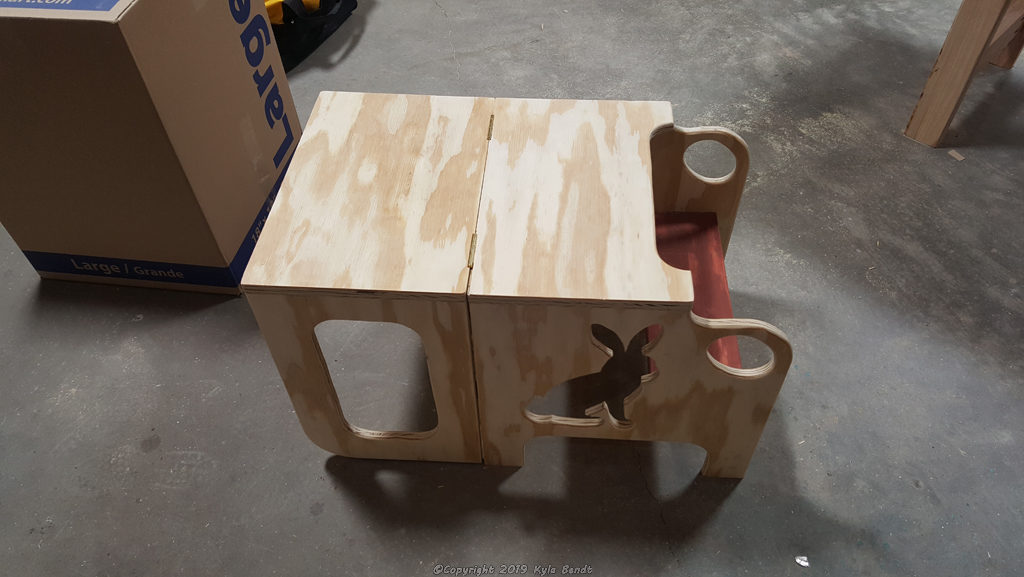 Unfinished convertible toddler step stool and table folded into table mode.